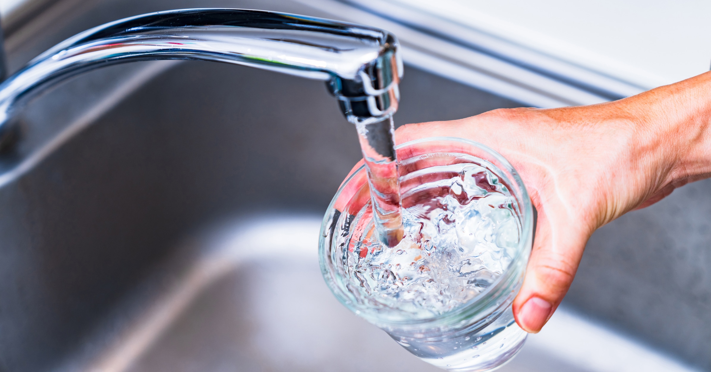 water being poured from kitchen faucet